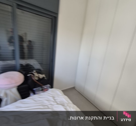 ארון בגדים לבן בנוי מותקן בחדר שינה
